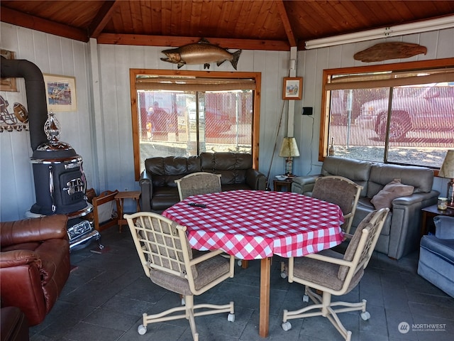 dining room featuring wooden ceiling, wood walls, and lofted ceiling with beams