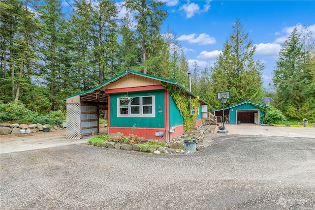 exterior space with a garage and an outbuilding