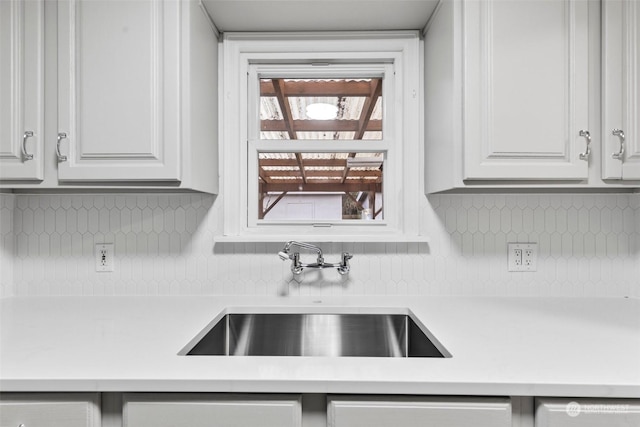 kitchen featuring sink, white cabinets, and tasteful backsplash