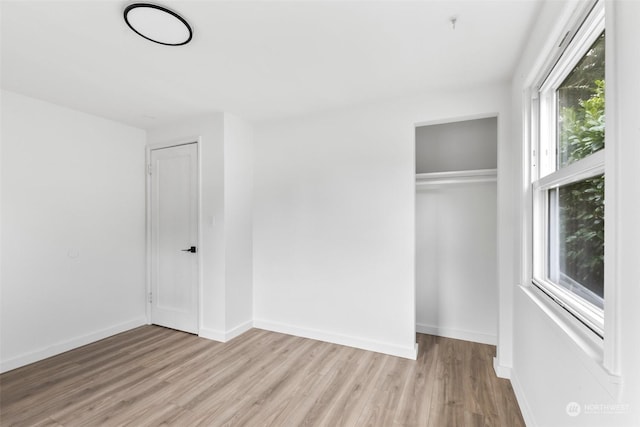 unfurnished bedroom with a closet and light hardwood / wood-style floors