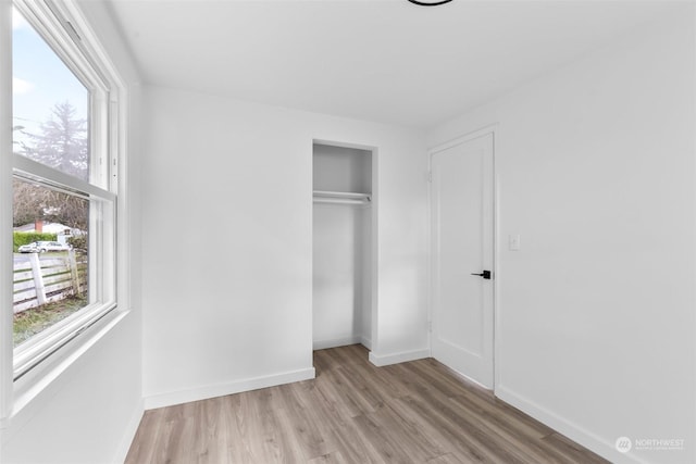 unfurnished bedroom featuring a closet and light hardwood / wood-style flooring