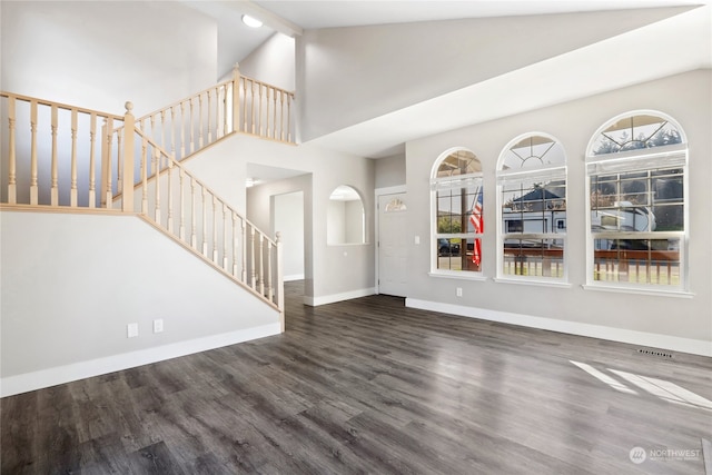 unfurnished living room with dark hardwood / wood-style floors and high vaulted ceiling