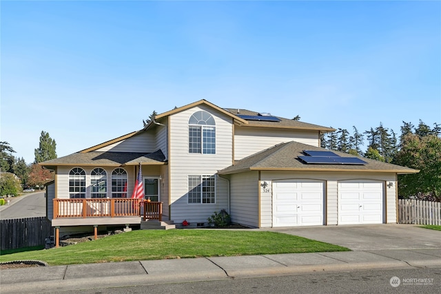 view of front property with a garage, a front lawn, and solar panels