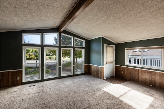 interior space with a textured ceiling, lofted ceiling with beams, wooden walls, and carpet flooring