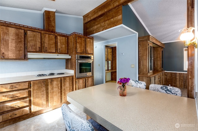 kitchen featuring oven, white gas stovetop, a textured ceiling, hanging light fixtures, and crown molding