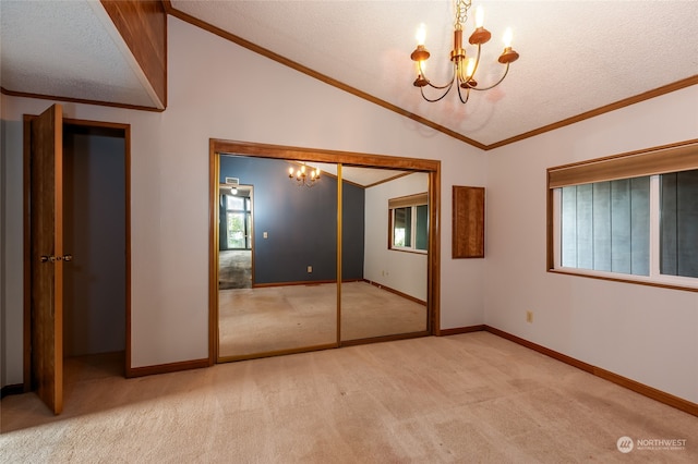 unfurnished bedroom featuring light carpet, a closet, a textured ceiling, and an inviting chandelier