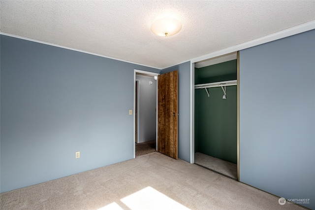 unfurnished bedroom with a closet, a textured ceiling, and carpet