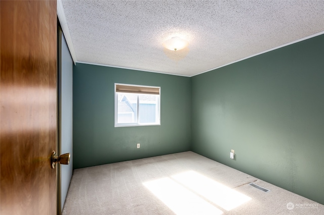 carpeted spare room with a textured ceiling