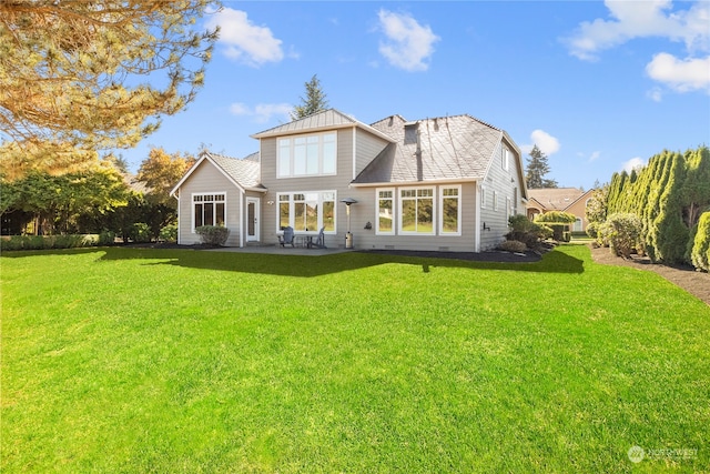 rear view of property featuring a lawn and a patio area