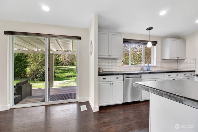 kitchen with sink, dark wood-type flooring, stainless steel dishwasher, decorative light fixtures, and white cabinets