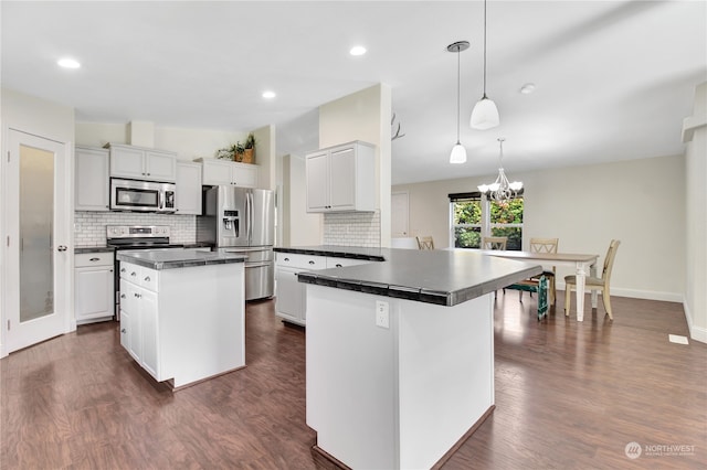 kitchen featuring white cabinets, appliances with stainless steel finishes, a center island, and dark hardwood / wood-style floors