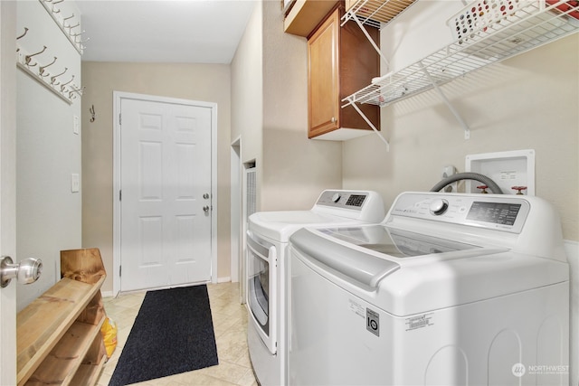 washroom featuring cabinets, washer and dryer, and light tile patterned flooring