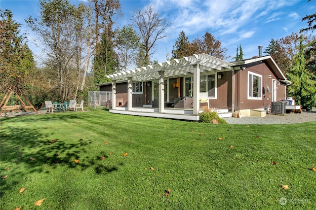 back of house with a yard, a pergola, and central AC unit