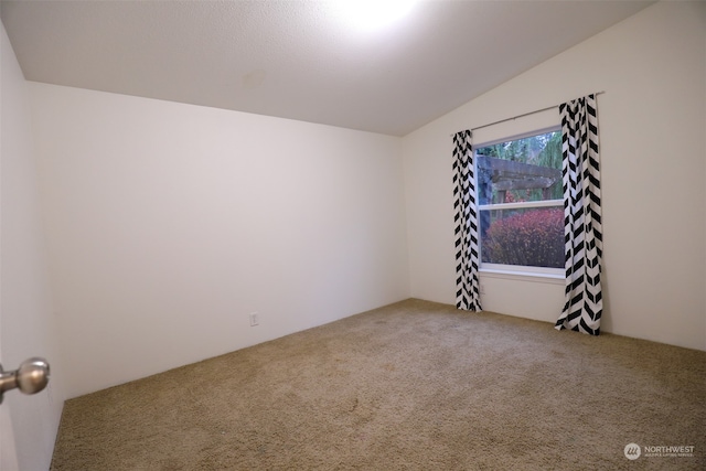 unfurnished room with carpet flooring and lofted ceiling