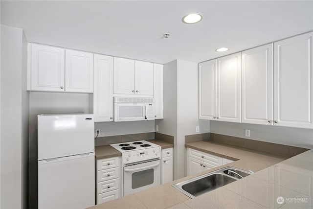 kitchen with white appliances, white cabinetry, and sink