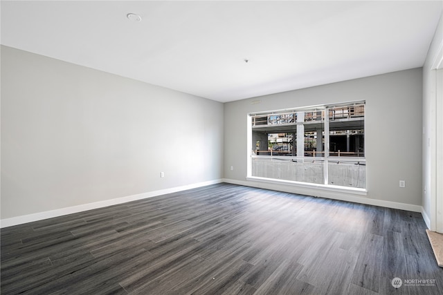 unfurnished room with dark hardwood / wood-style flooring