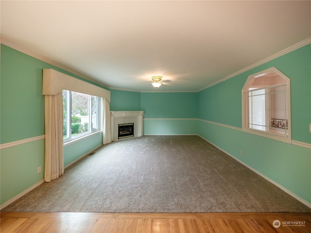 unfurnished living room featuring ornamental molding, carpet floors, and ceiling fan