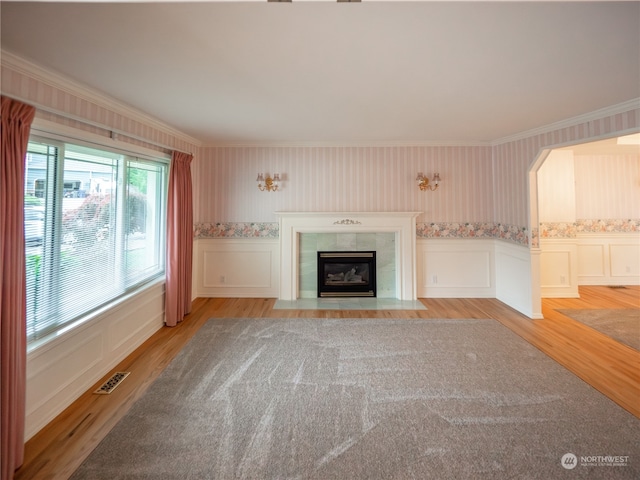 unfurnished living room featuring ornamental molding, light hardwood / wood-style flooring, and a fireplace