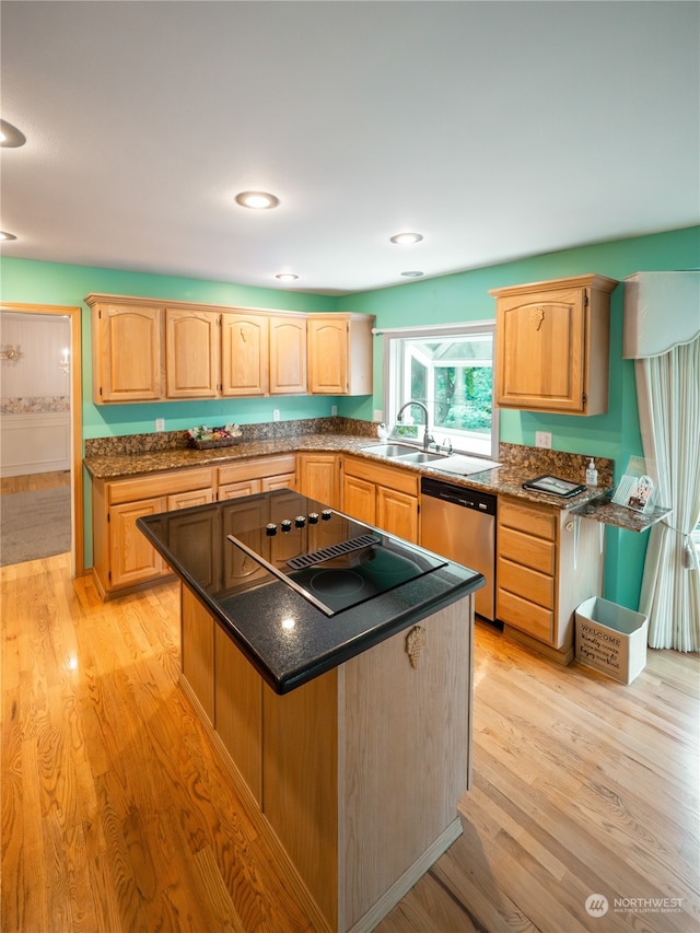 kitchen featuring dishwasher, sink, light hardwood / wood-style floors, black electric stovetop, and a center island