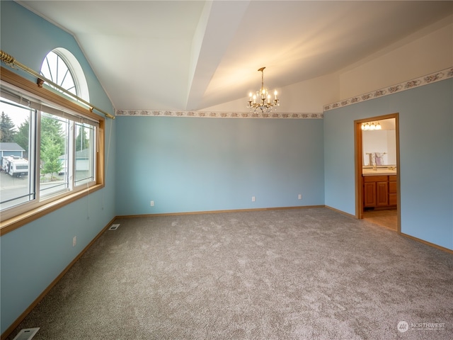 carpeted empty room with vaulted ceiling and an inviting chandelier