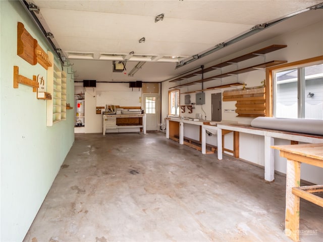 garage featuring electric panel, a workshop area, and gas water heater