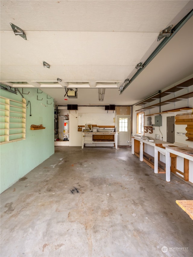 garage featuring electric panel, water heater, and a garage door opener