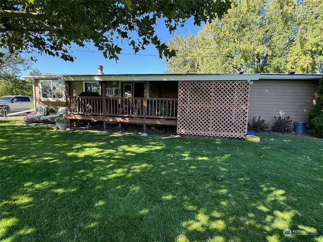 rear view of house featuring a deck and a yard