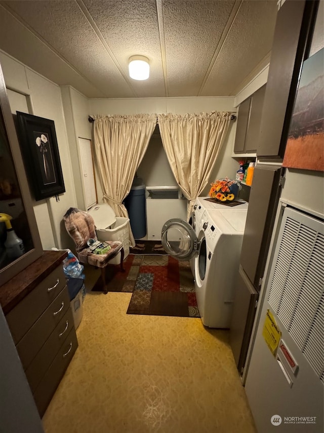 laundry room featuring carpet, washer and dryer, and a textured ceiling