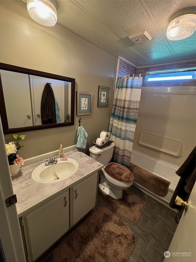 bathroom with vanity, toilet, a textured ceiling, and curtained shower