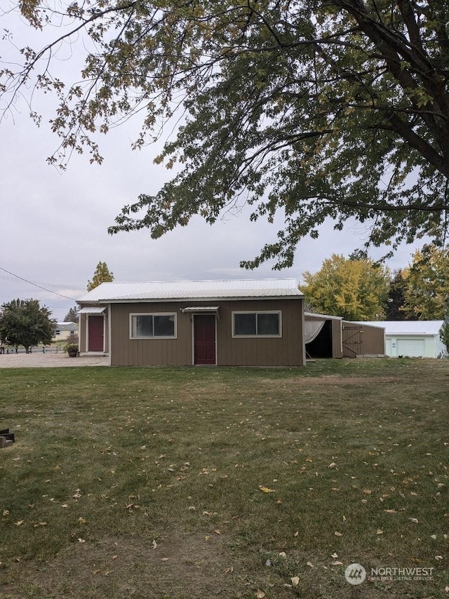 view of front of home featuring an outdoor structure and a front lawn