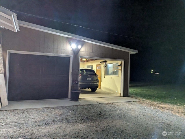 view of garage at twilight