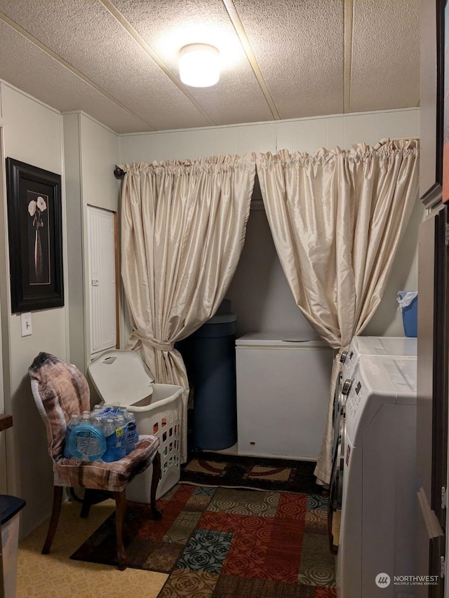 washroom with dark carpet, washer and dryer, and a textured ceiling