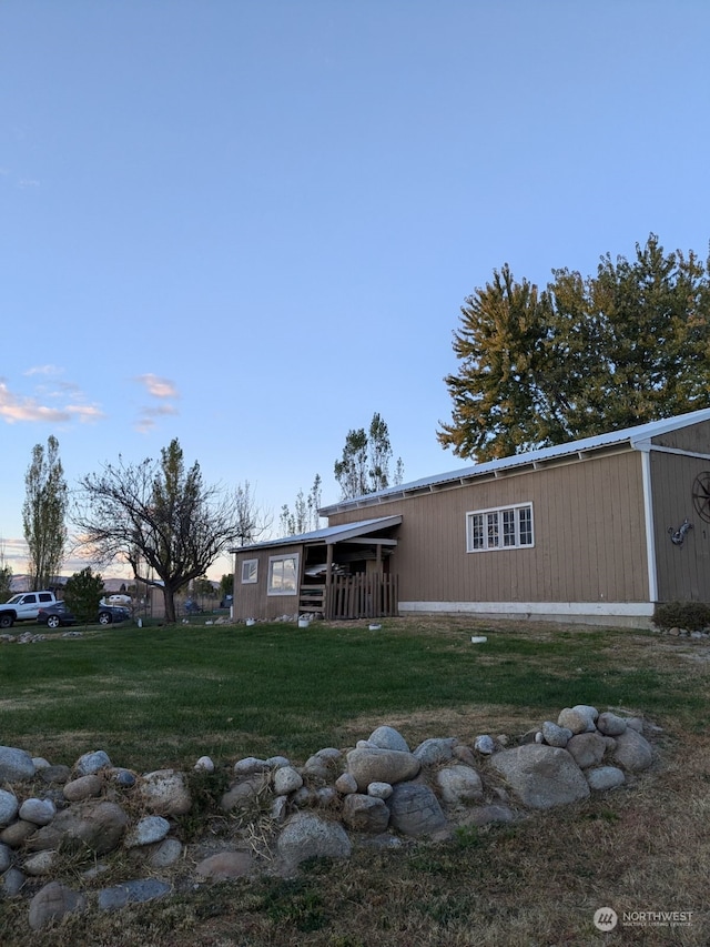 back house at dusk with a lawn