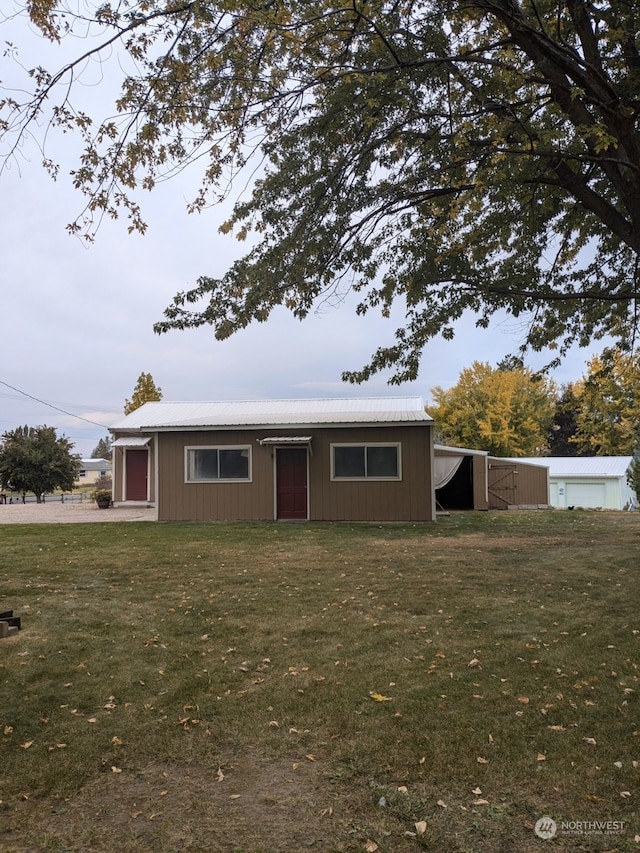 view of front of property featuring a front yard and an outdoor structure