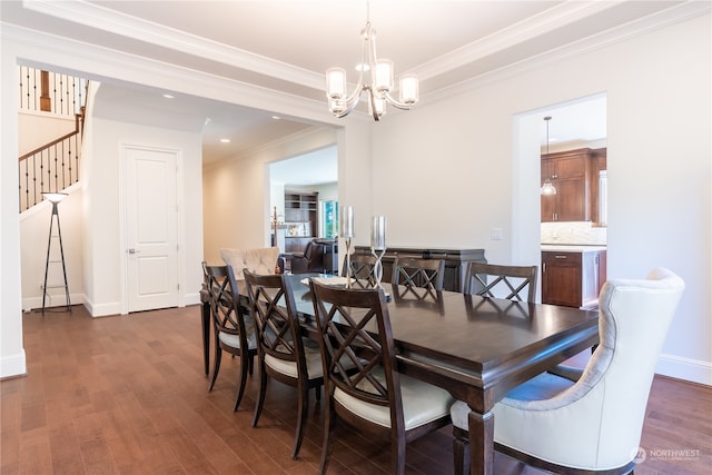 dining room with an inviting chandelier, ornamental molding, and dark hardwood / wood-style floors