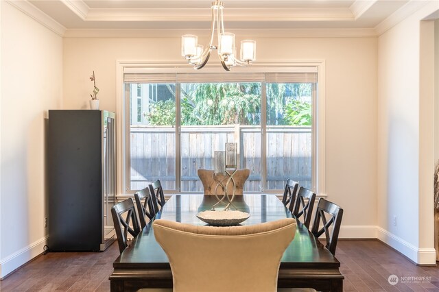 dining room featuring an inviting chandelier, ornamental molding, a tray ceiling, and dark hardwood / wood-style flooring