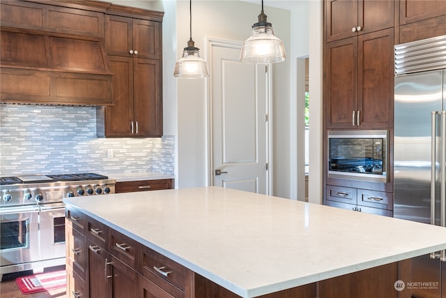 kitchen featuring tasteful backsplash, built in appliances, pendant lighting, a center island, and custom exhaust hood