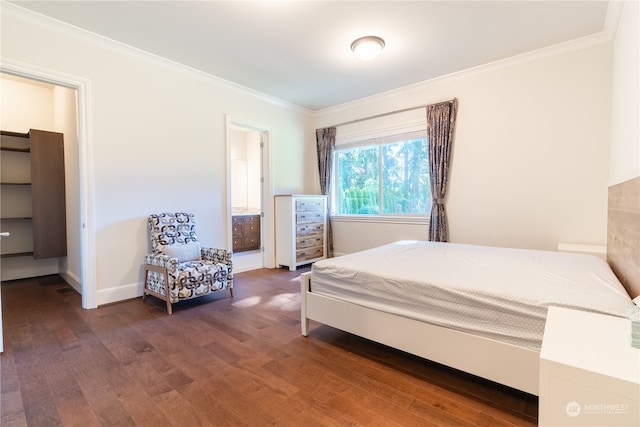 bedroom with ensuite bath, dark hardwood / wood-style flooring, and crown molding