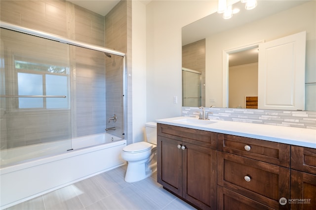 full bathroom with decorative backsplash, vanity, tile patterned flooring, shower / bath combination with glass door, and toilet