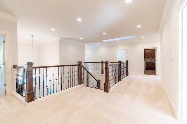 corridor with crown molding, light carpet, and a skylight