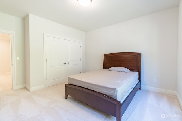 bedroom with light colored carpet and a closet