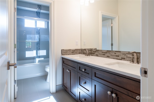 full bathroom featuring combined bath / shower with glass door, decorative backsplash, tile patterned floors, vanity, and toilet