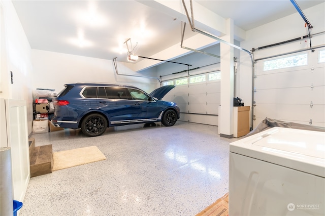 garage with a garage door opener and washer / dryer