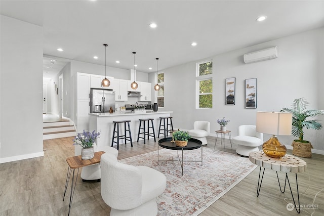 living room featuring an AC wall unit and light hardwood / wood-style flooring