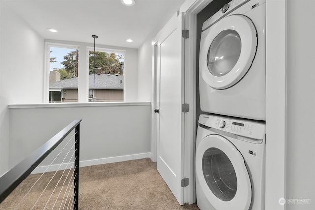 laundry room with light colored carpet and stacked washer / dryer