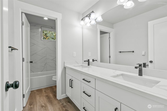 full bathroom featuring toilet, tiled shower / bath combo, vanity, and hardwood / wood-style floors