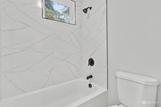 bathroom featuring toilet and tiled shower / bath combo