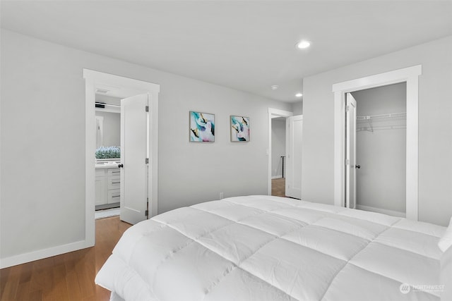 bedroom featuring ensuite bathroom, hardwood / wood-style floors, a walk in closet, and a closet