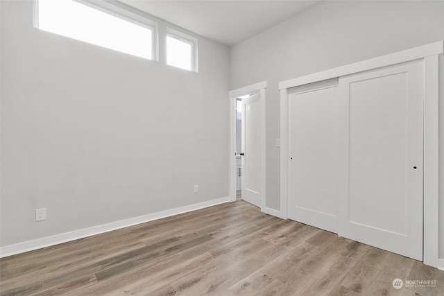 unfurnished bedroom with a closet and light hardwood / wood-style flooring