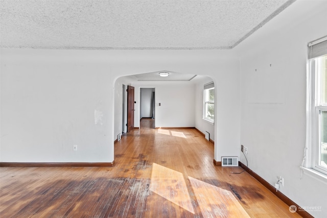 empty room with a textured ceiling and hardwood / wood-style flooring